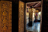 Wat Xieng Thong temple in Luang Prabang, Laos. The sim s interior is extensively decorated with intricate gold stencilling on black lacquer. Large stencilled teak wood pillars support the roof.  